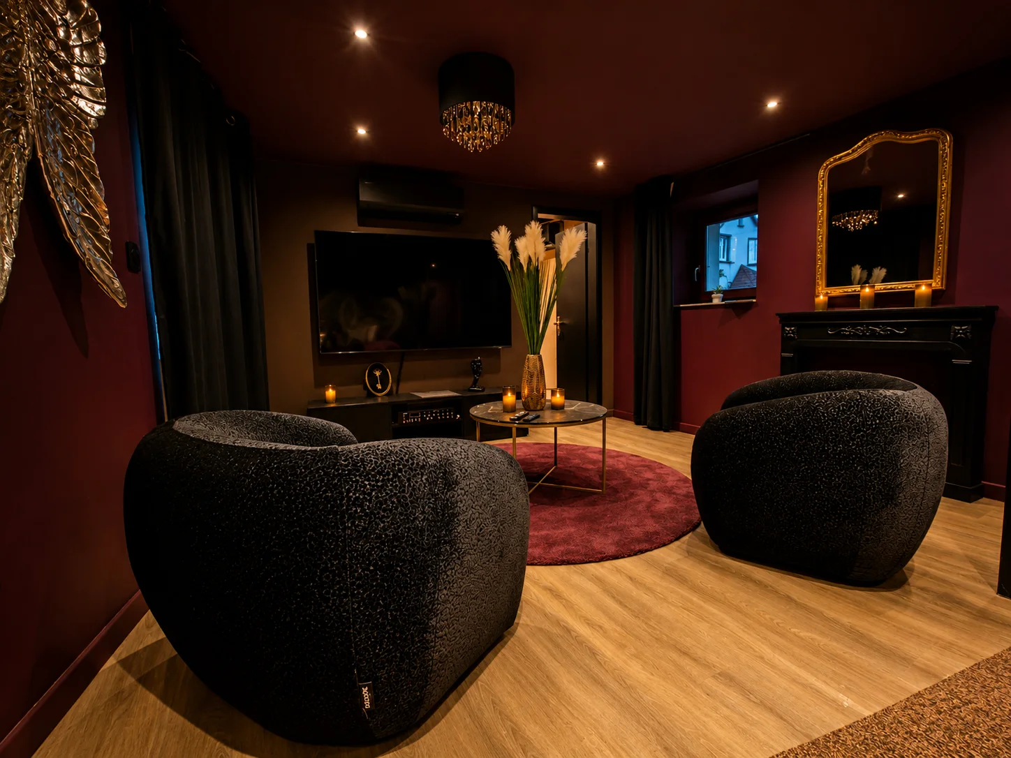Salon privatif avec fauteuils et télévision dans la Love Room à Wissembourg
